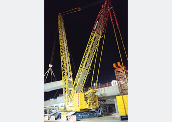 A Demag crane lifts bridge sections.