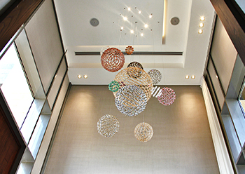 Hellbob chandeliers float like planets within the impressive height of the entrance.