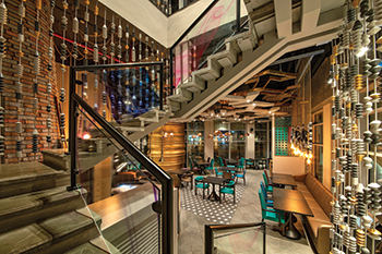 The balustrades of the concrete staircase comprise metal rods threaded through oversized wooden beadwork.