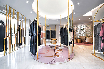 Gold is used on custom undulating curved fixtures from which clothing is displayed.